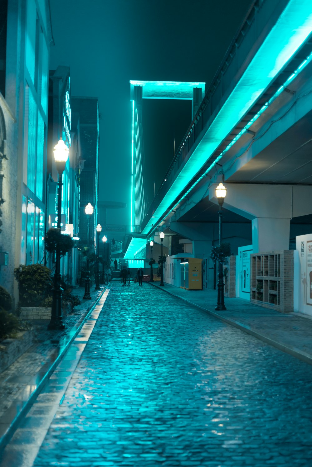 a city street at night with a bridge in the background