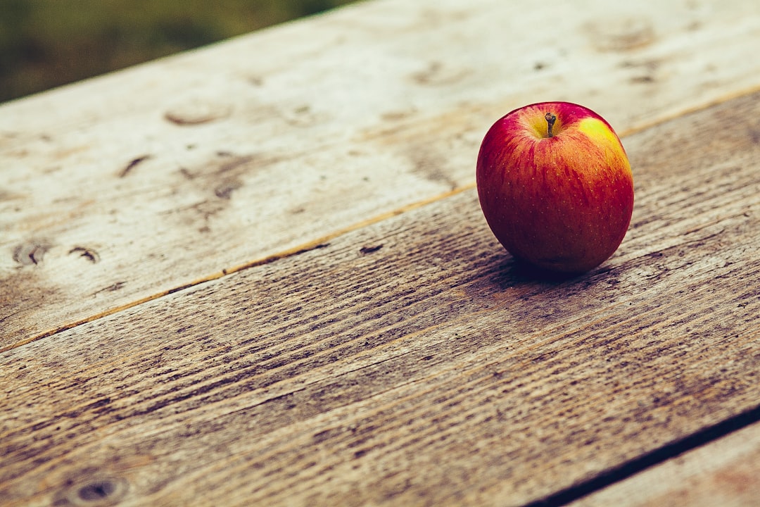 red apple on brown surface