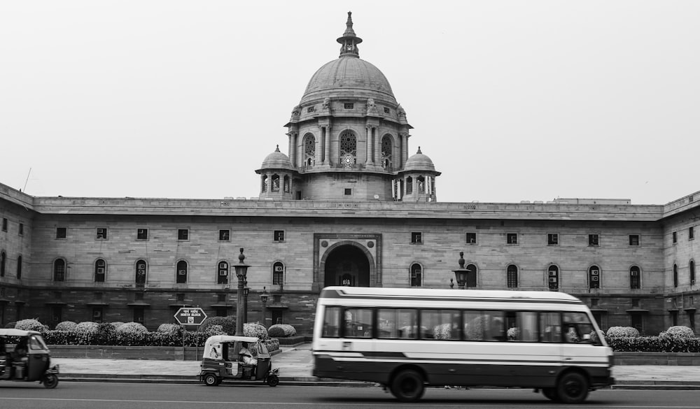 grayscale photography of bus infront of building