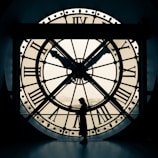 person standing beside wall clock