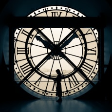 person standing beside wall clock