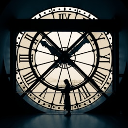 person standing beside wall clock
