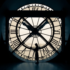 person standing beside wall clock
