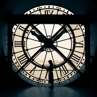person standing beside wall clock