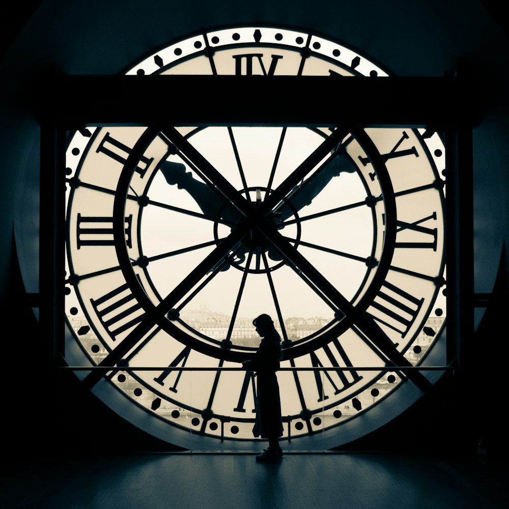 person standing beside wall clock