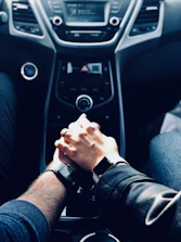 A close-up of hands shaking over a signed car purchase agreement.