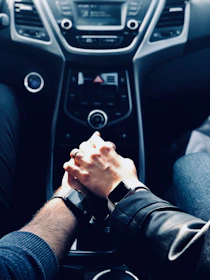 A close-up of hands shaking over a signed car purchase agreement.