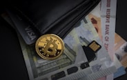 a bitcoin sitting on top of a pile of money