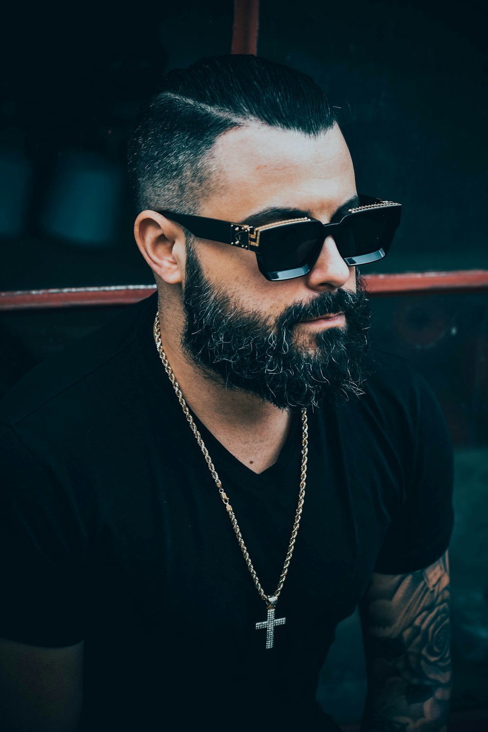 man in black shirt wearing sunglasses by glass wall