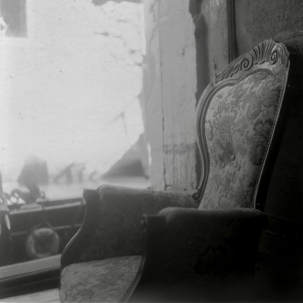 an old chair sitting in front of a window