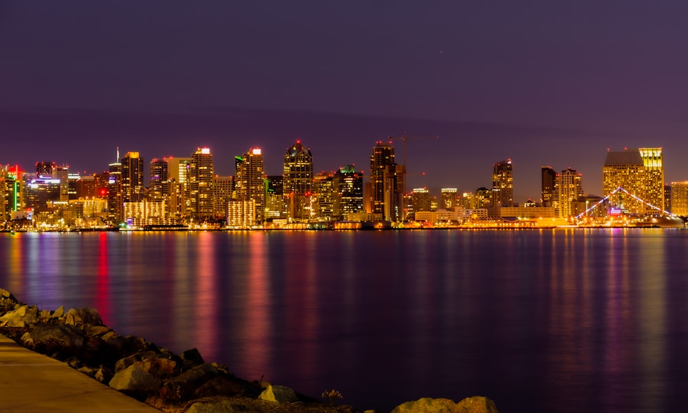 photo of buildings besside sea during nighttime