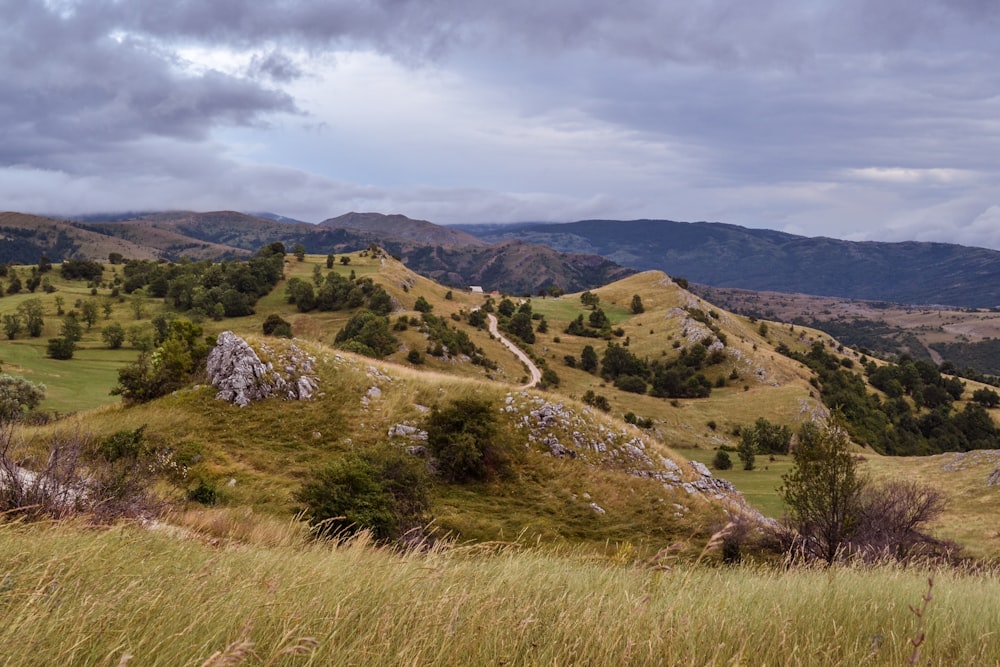 nature photography of green mountains under cloudy sky during daytime