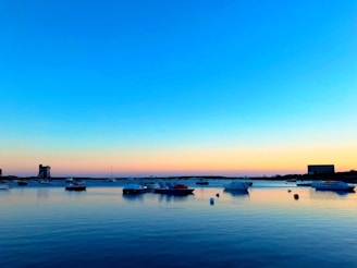 A serene coastal scene at sunset with fishermen preparing their boats.