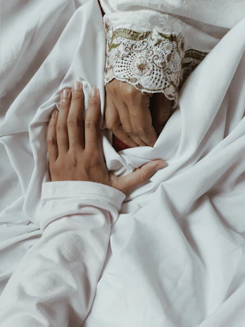 Close-up of a hand gently holding a delicate silk scarf, symbolizing discretion and secret pleasures.