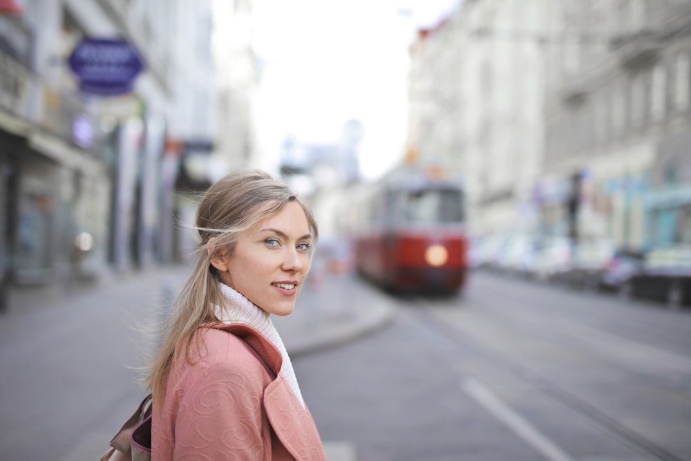 selective focus photography of woman standing near train during daytime