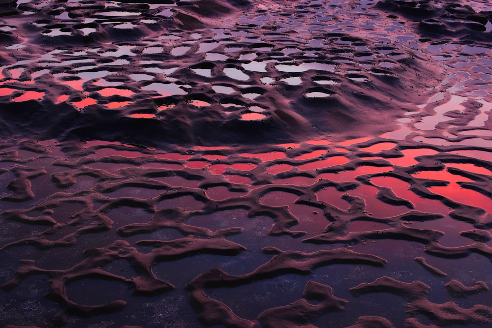 a close up of water and sand with a sky in the background