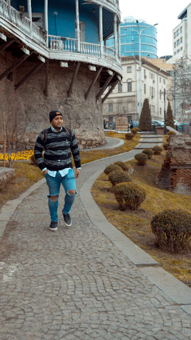 A model wearing a cozy, minimalist sweater walking through a sunny Cork street.