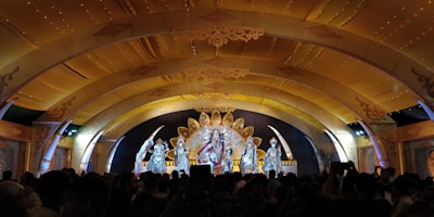 A festive scene with a stage decorated for the San Marcos fair, with contestants presenting.