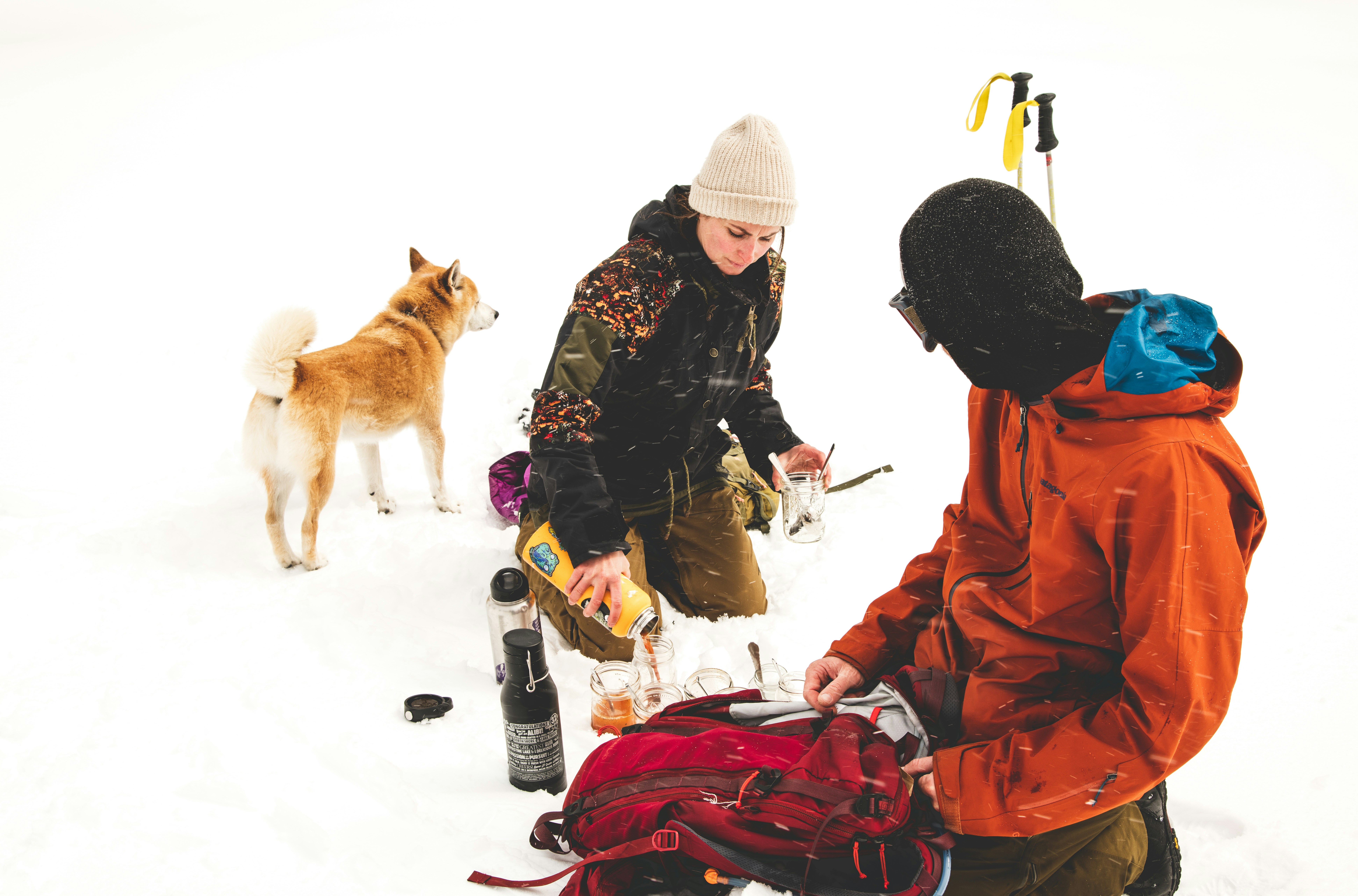 two persons sitting on snowy ground