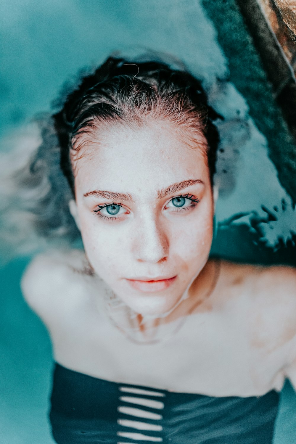 woman in black swimwear dipping in water