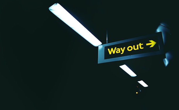 a black and yellow sign that says way out
