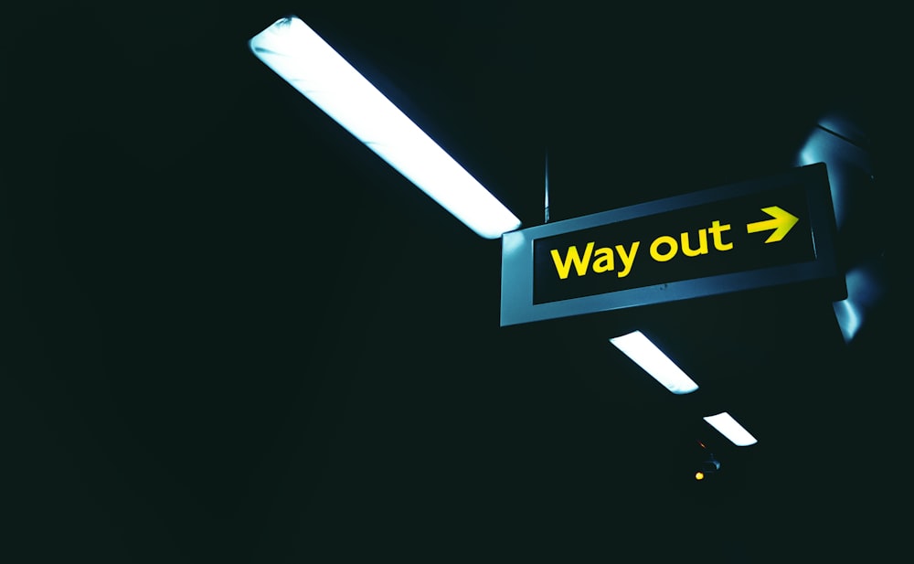a black and yellow sign that says way out