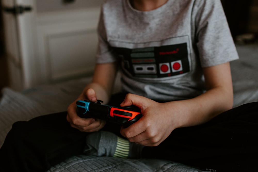 kid sitting on gray bed while playing