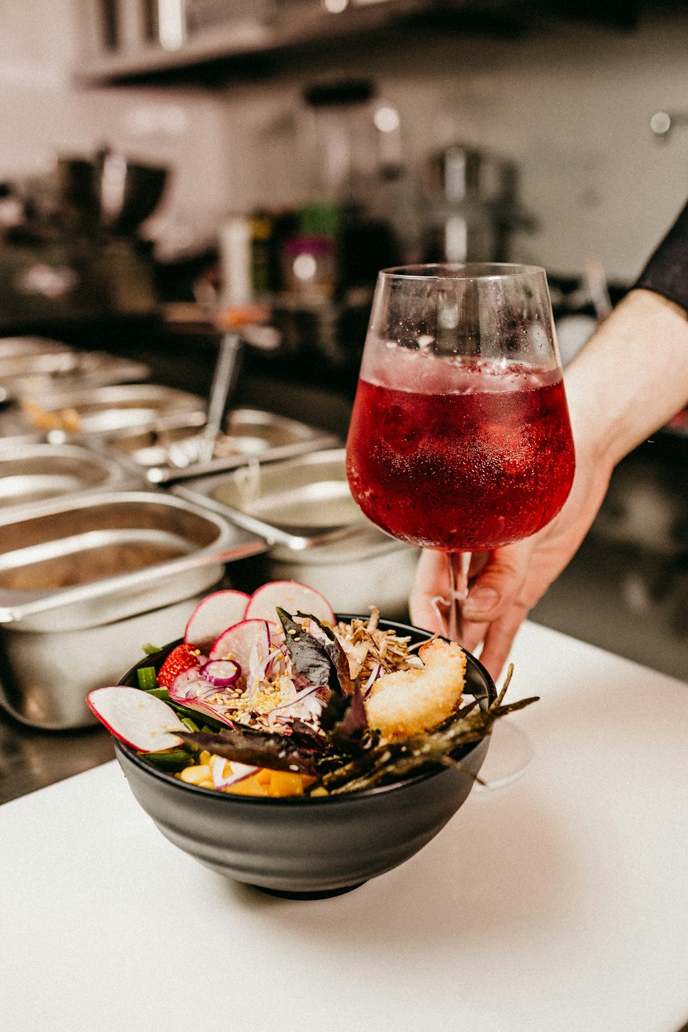 red wine in clear wine glass beside bowl full of food