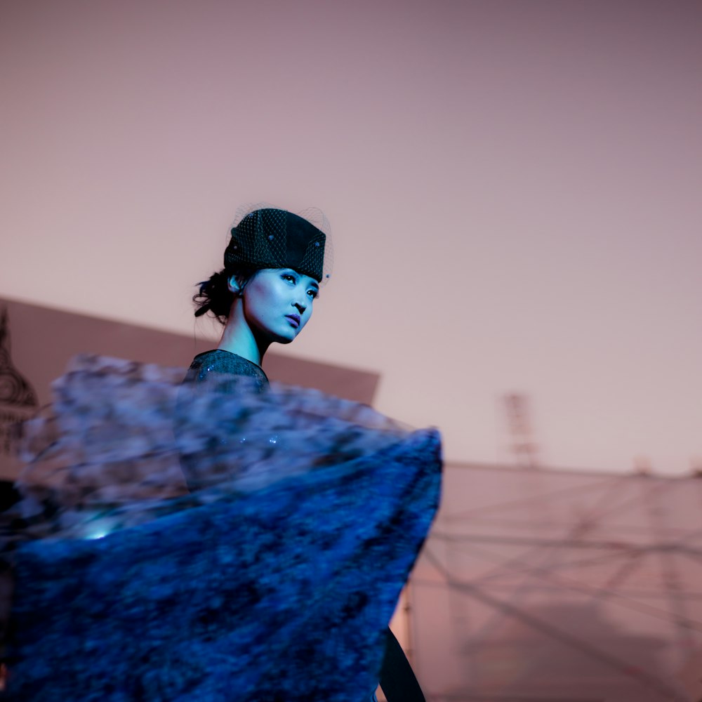 woman in blue and black lace dress and black hat