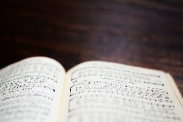 Sheet music pages gently spread out on a minimalist wooden table.