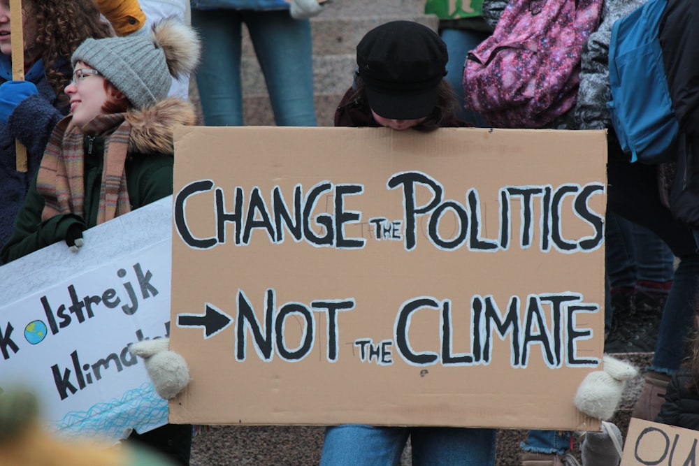 Person, die die Politik ändert, nicht das Klima gedruckte Tafel