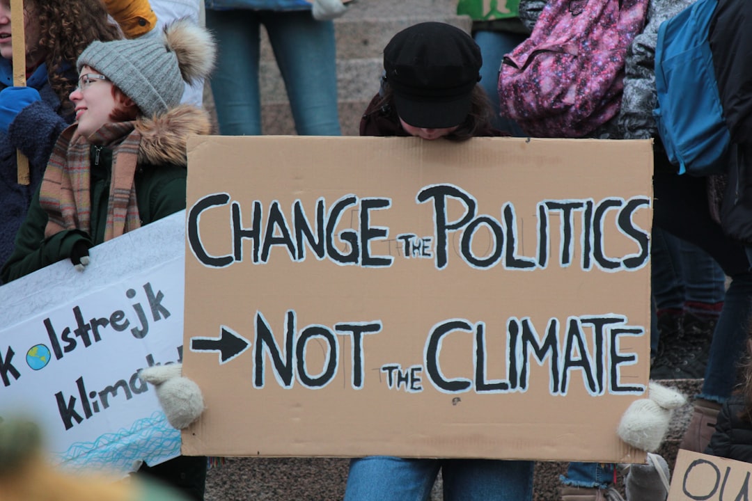 person holding change the politics not the climate printed board,