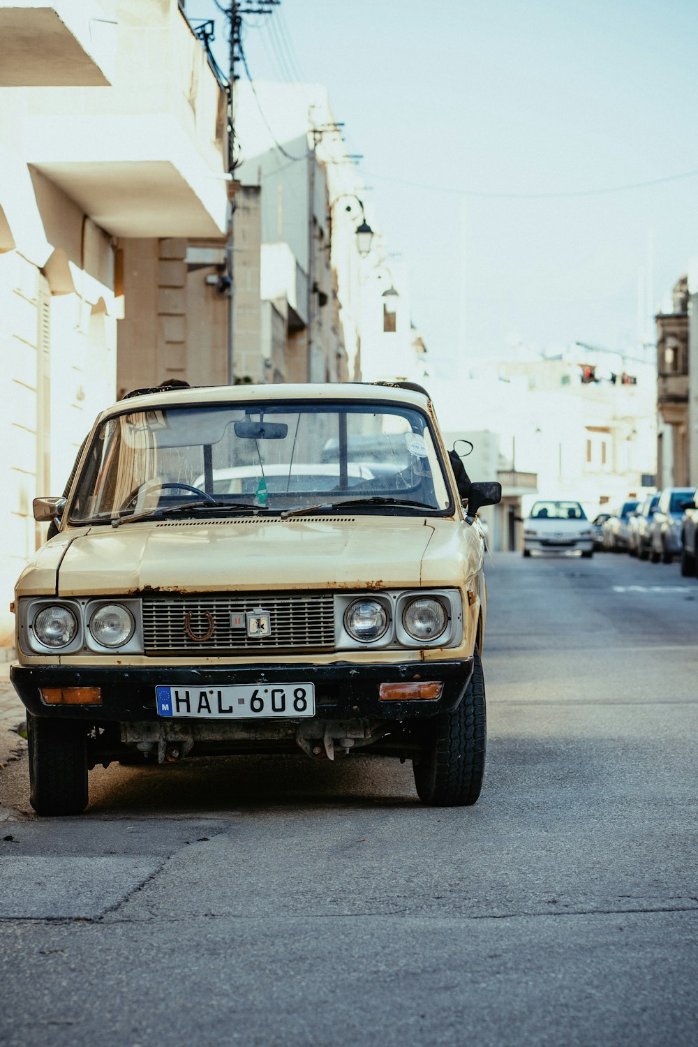 Auto marrone parcheggiata accanto al muro