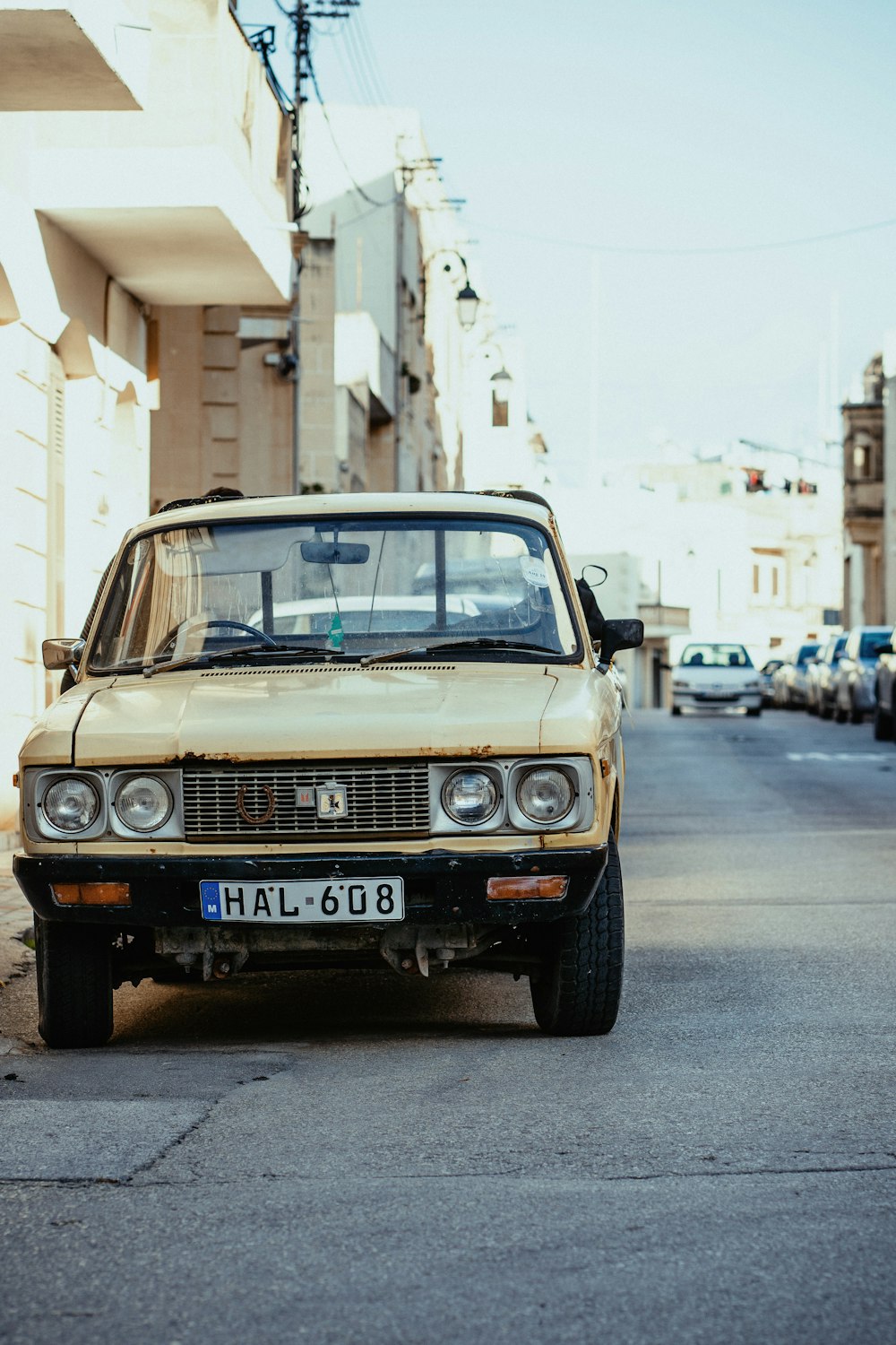 brown car parked beside wall