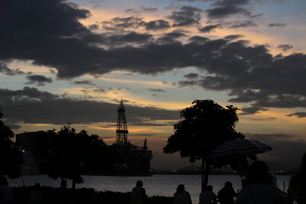 A panoramic view of an oil rig silhouetted against a deep green twilight sky.