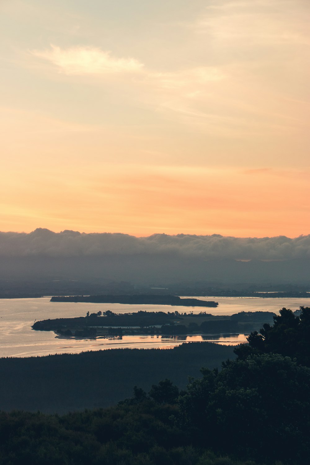 body of water near mountain in silhouette photography