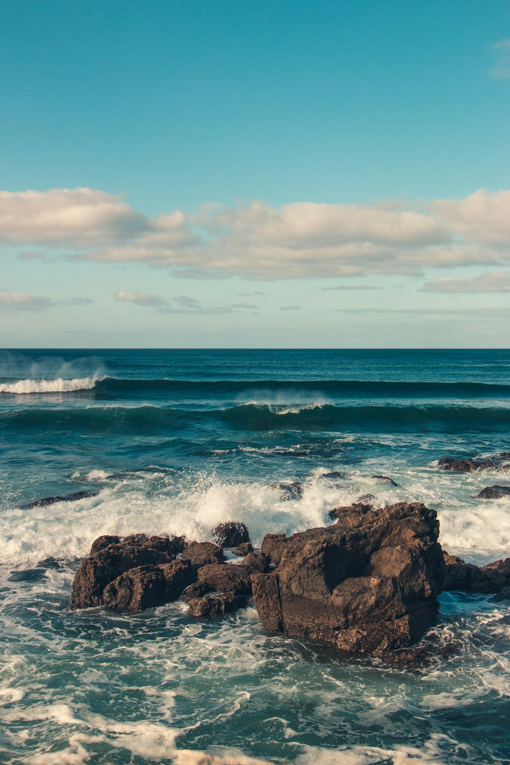 Onde dell'oceano che spruzzi sulle rocce durante il giorno