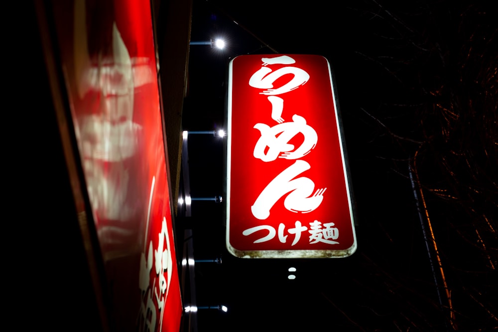 lighted white and red signage at night