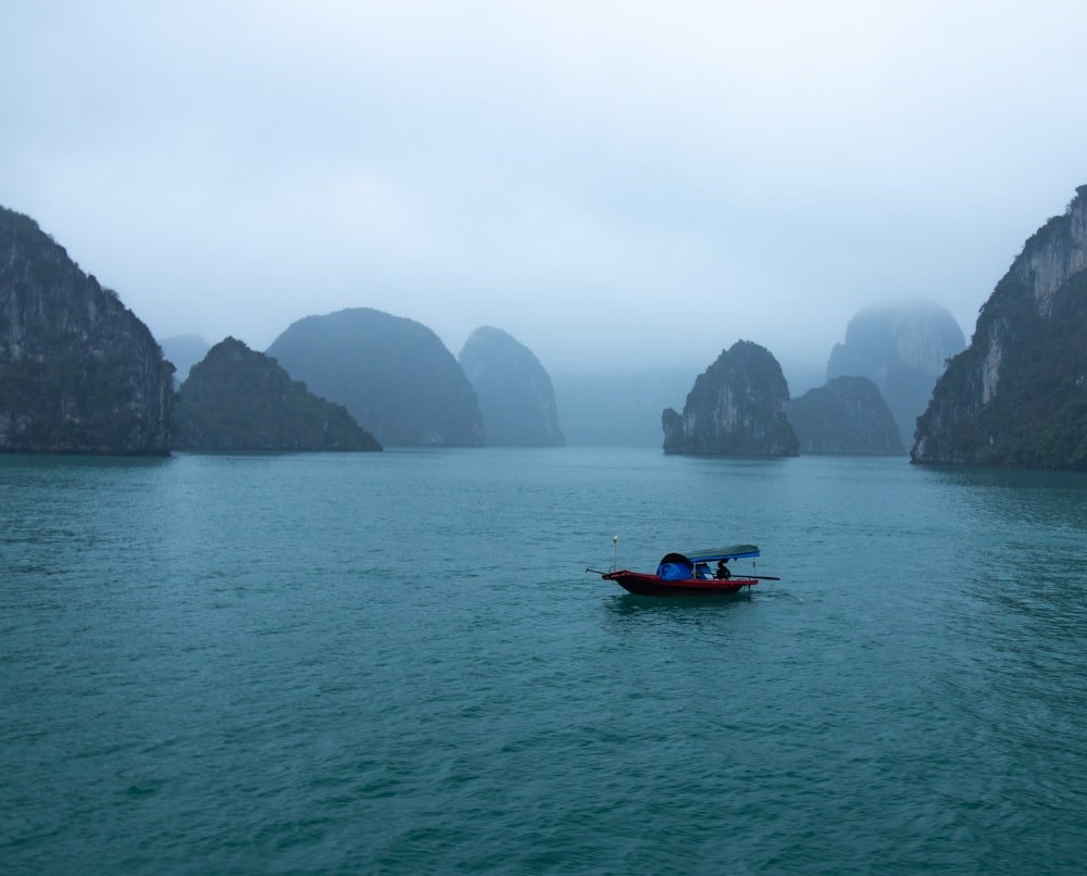 blue and red boat on body of water