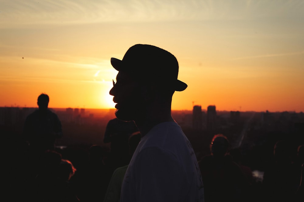 man wearing white shirt and black hat during golden hour