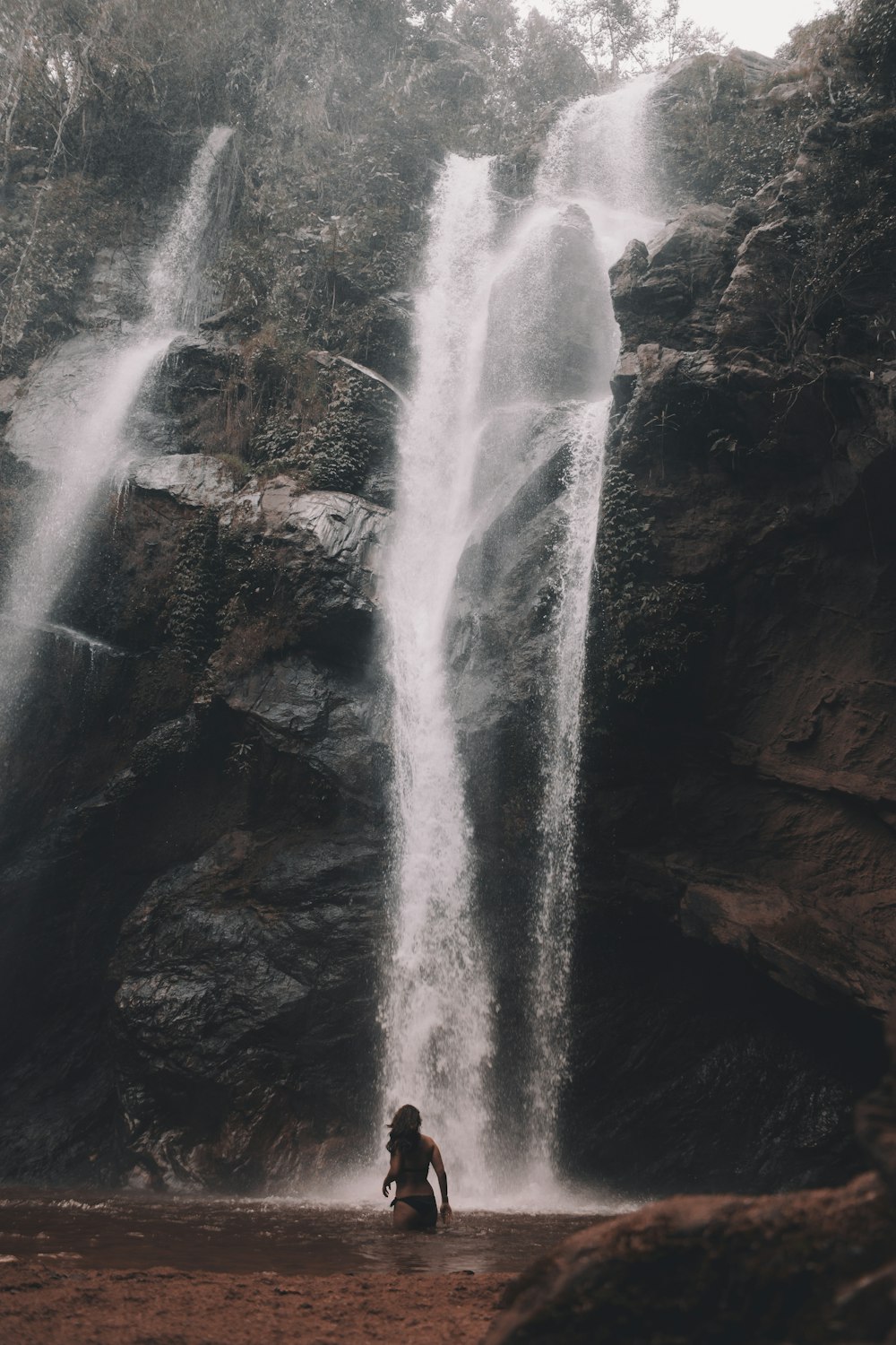 woman standing in front of waterfalls