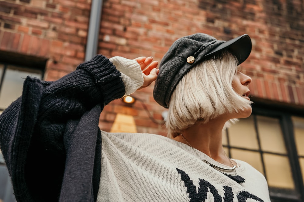 woman in gray sweater standing near building