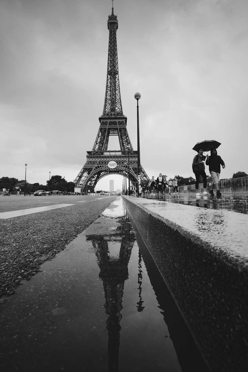 two women walking with umbrella from the Eiffel Tower