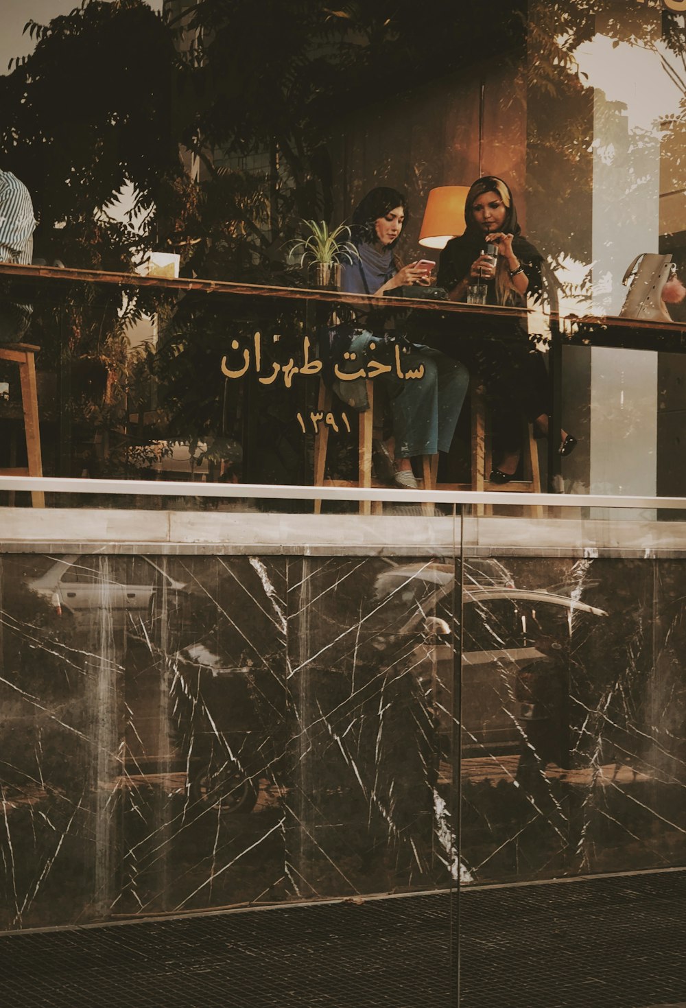 woman sitting beside woman while using smartphone