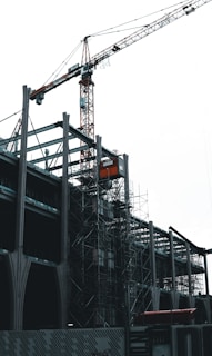 Overzicht van een halfafgewerkt kantoorcomplex met kraan en bouwmaterialen