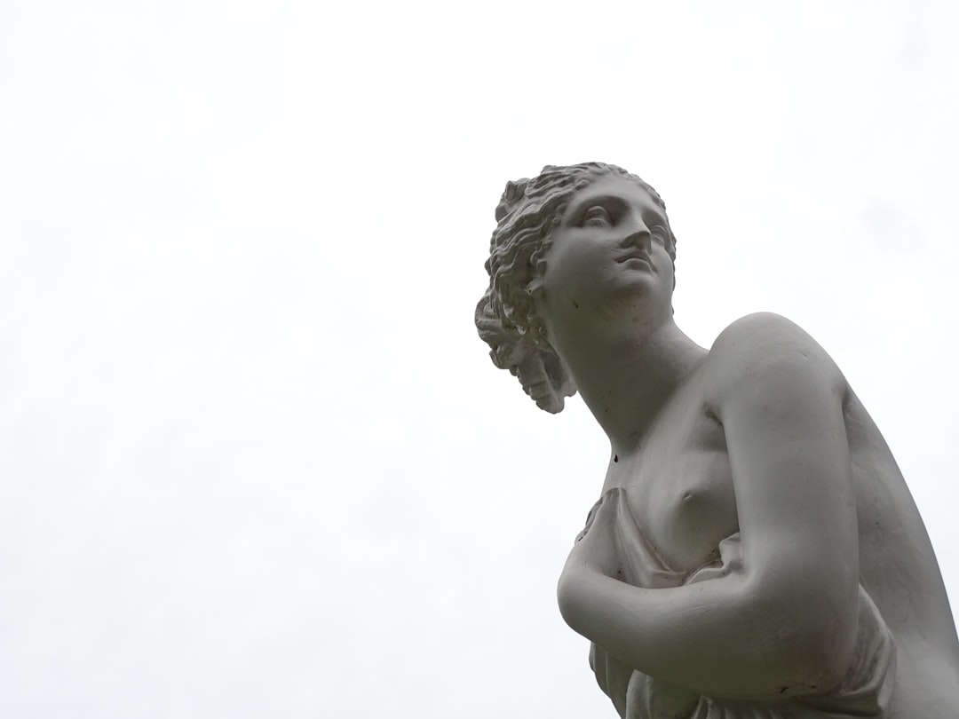 topless woman statue, Sculpture of a lady hiding her body behind a piece of fabric.