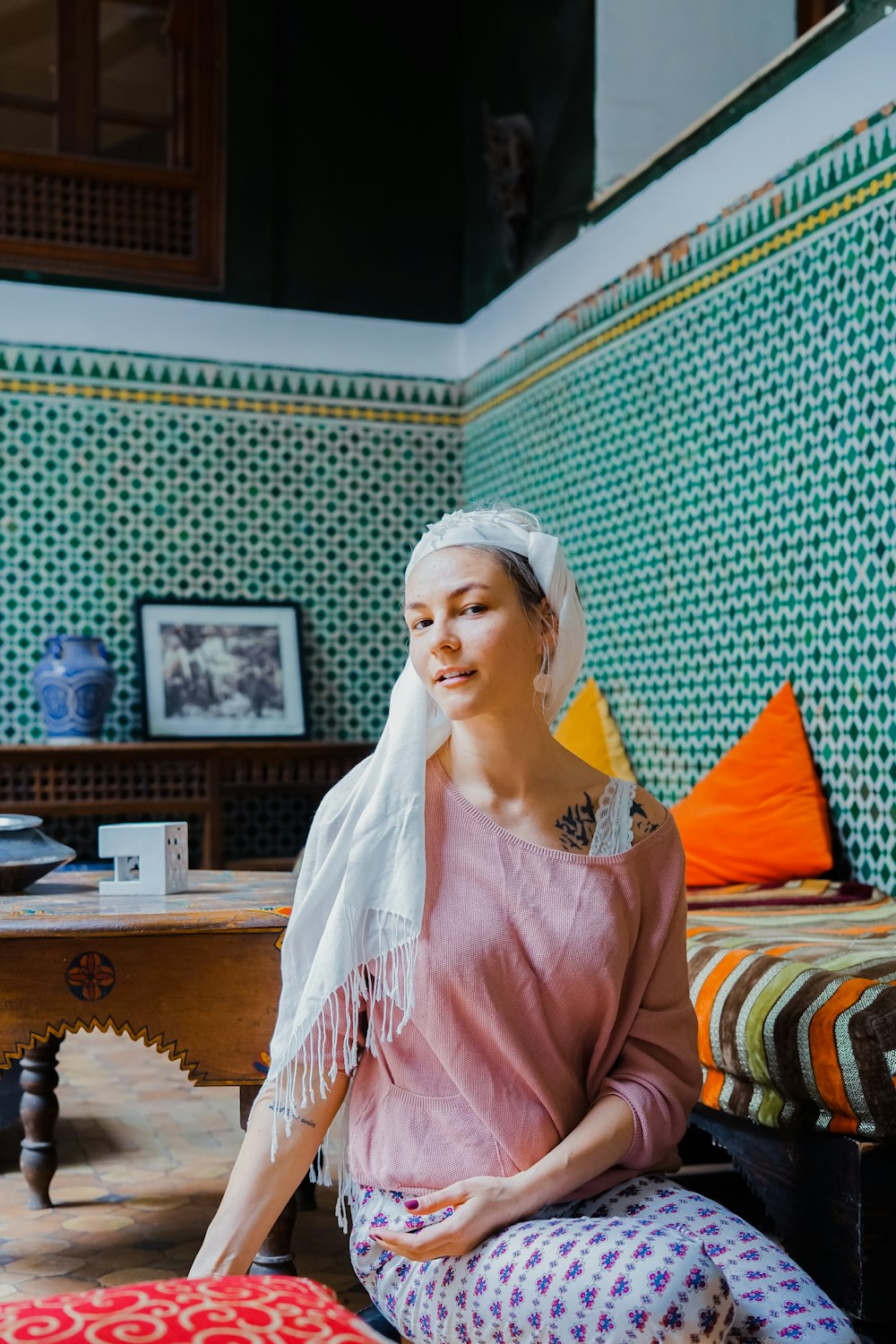 woman with headscarf sitting near bed
