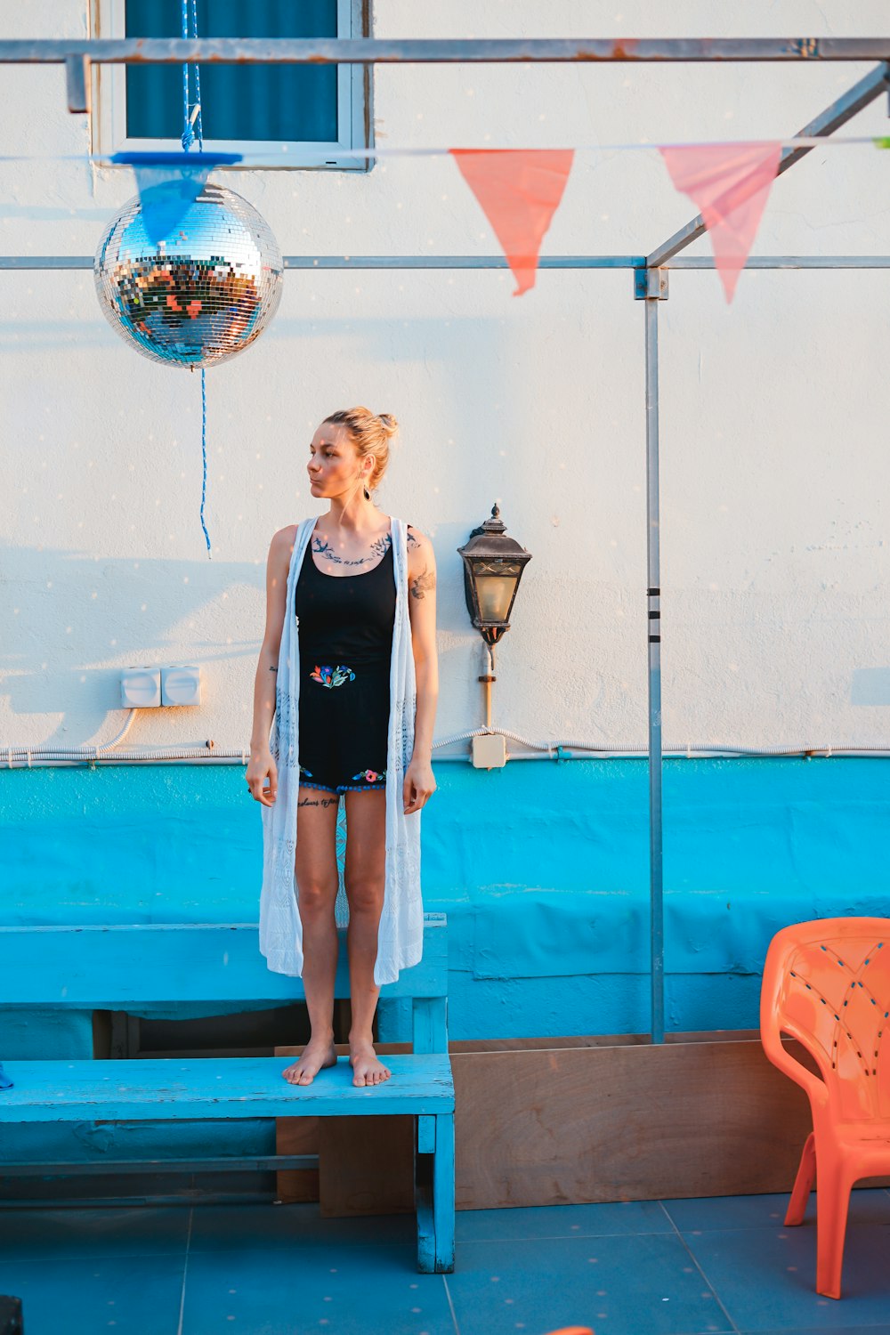 woman standing on blue-painted bench