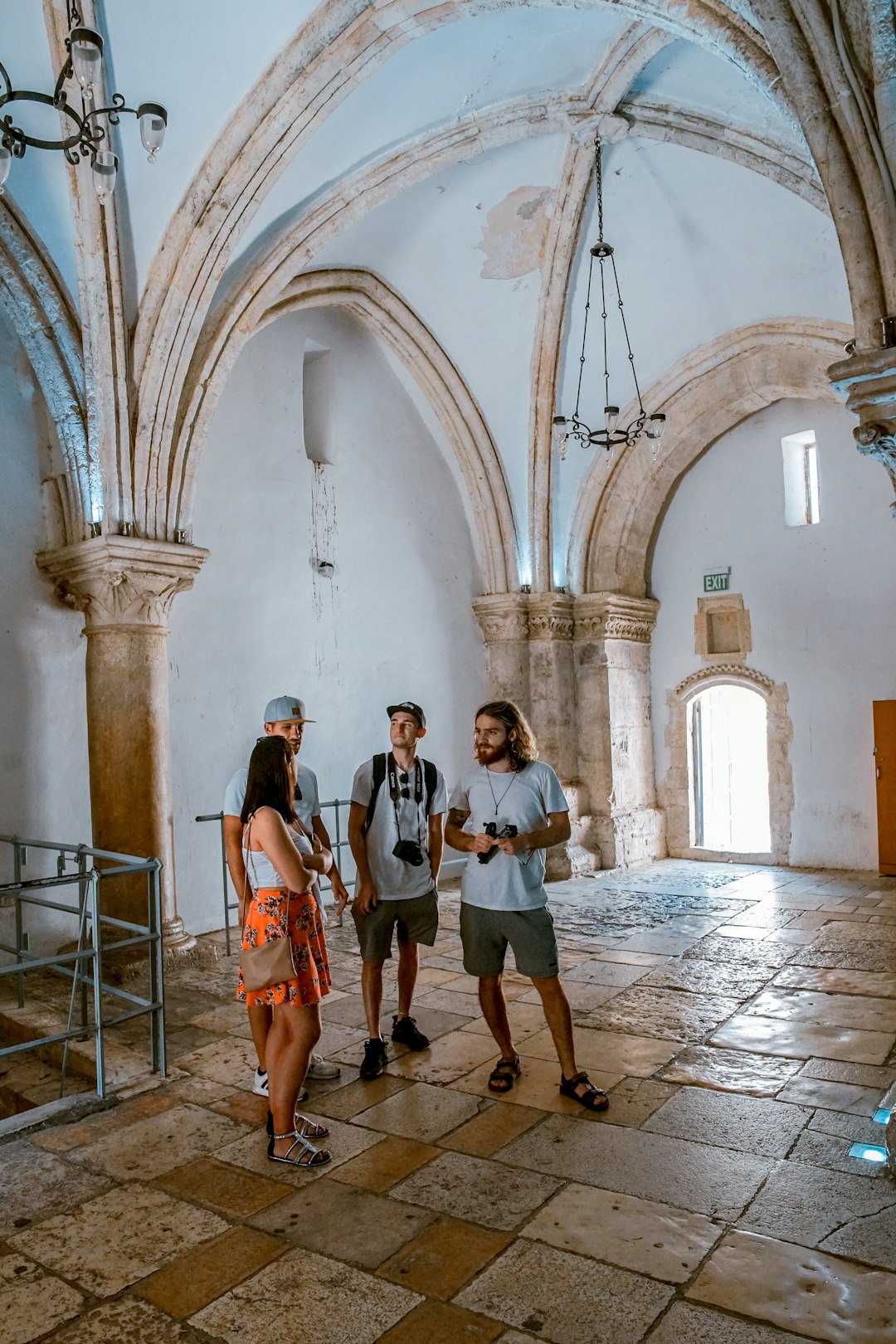 three men standing in front of woman inside building