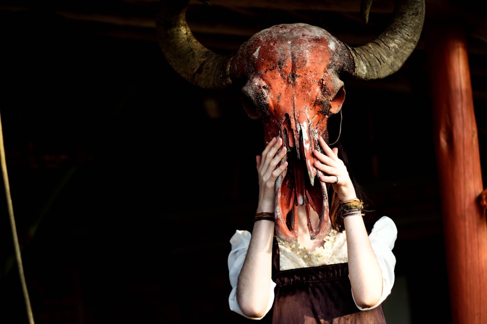 a woman with a horned head covering her face